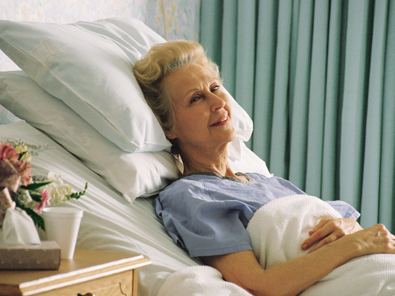 Elderly woman smiling in hospital bed