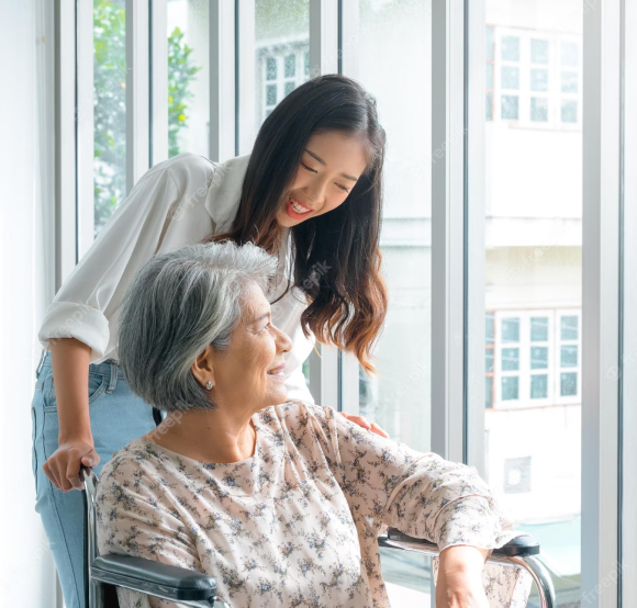 Caregiver and senior lady talking and smiling together by the window