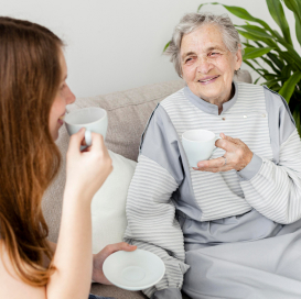 senior lady and young lady drink tea together