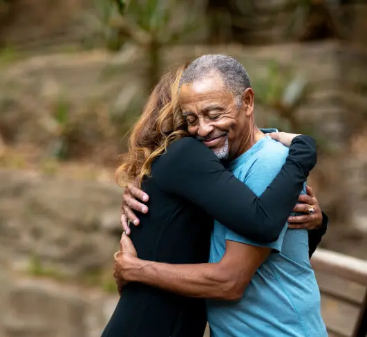 a young woman hugs an old man
